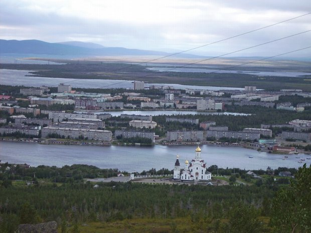 View of the town Monchegorsk. To the left (outside the frame) are the large nickel smelters, responsible for massive pollution of the environment. The town is beautifully located on lake Imandra, while the mining company recently payed for the erection of a church in the traditional Russian style, instead of reducing the outlet of massive amounts of acid fiumes from the smelters. Photo: Rasmus Ole Rasmussen